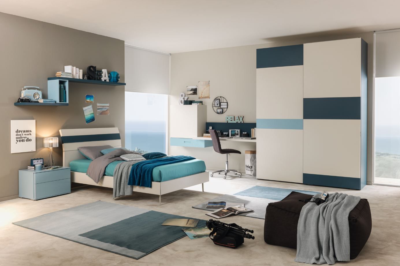 Camera da letto moderna con mobili blu e bianchi: letto, scrivania, armadio, tappeto.