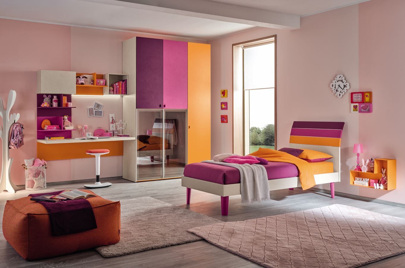 Una camera da letto dai colori vivaci con mobili rosa, arancioni e viola, tra cui un letto, una scrivania e un armadio.