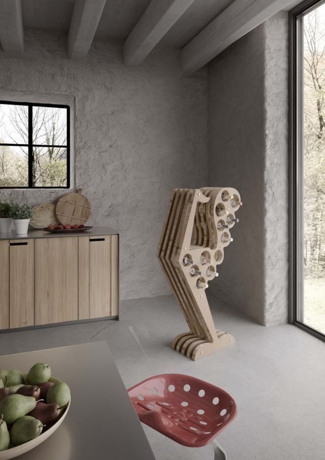 Moderno portabottiglie in una stanza rustica; in primo piano una ciotola di frutta e una sedia rossa.