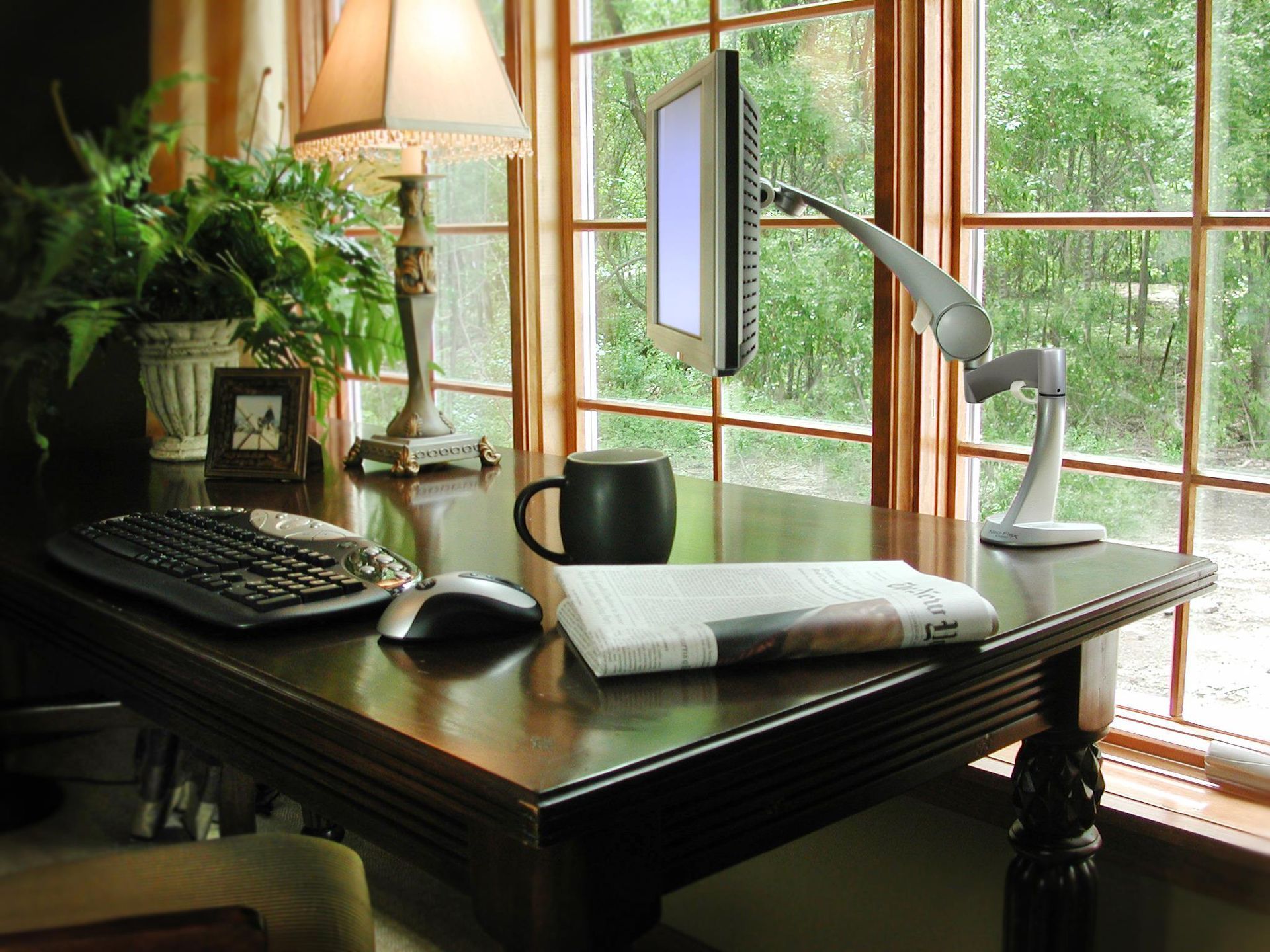 A desk with a computer and a newspaper on it