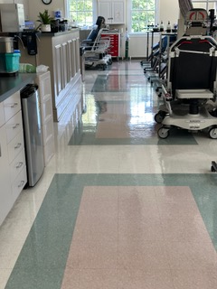 A hospital hallway with a pink and green tile floor