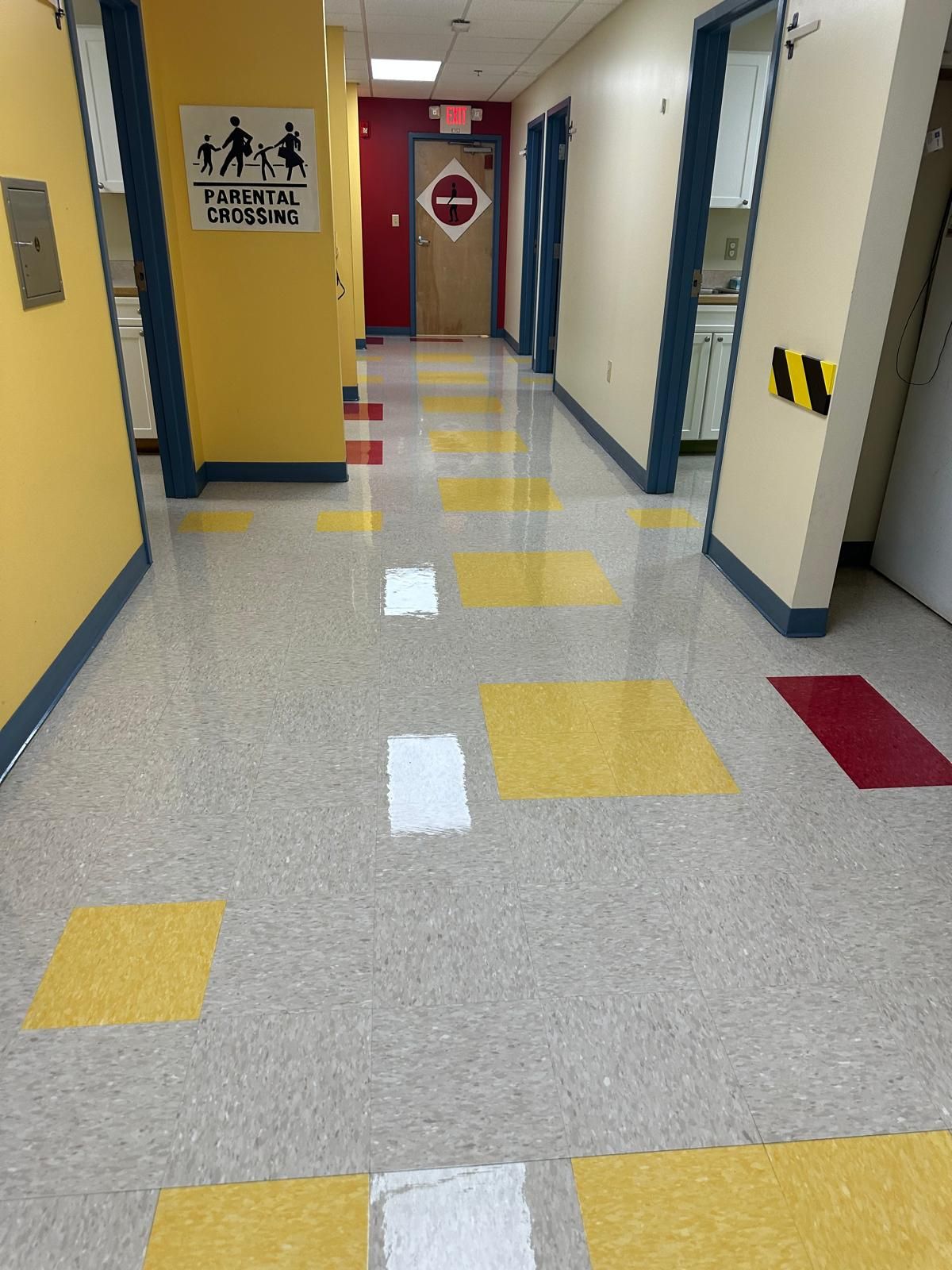 Professional janitorial floor care in a medical office hallway with yellow tiles