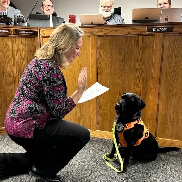 Village Clerk Lori Romine administering the oath of office to Antioch Police comfort dog, Flo.