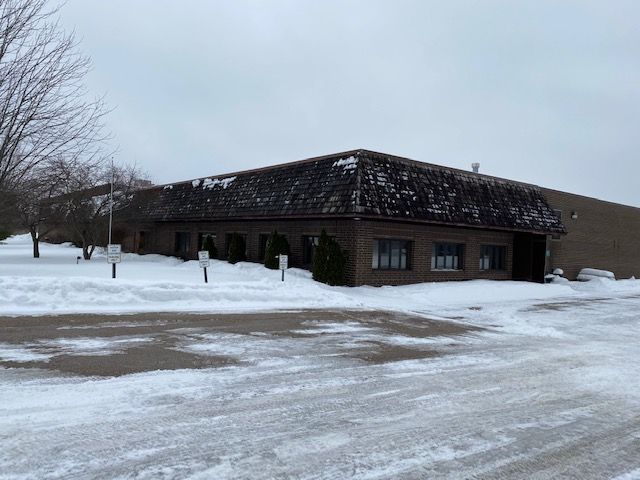 Building with dark roof and brick facade, in a snowy setting.