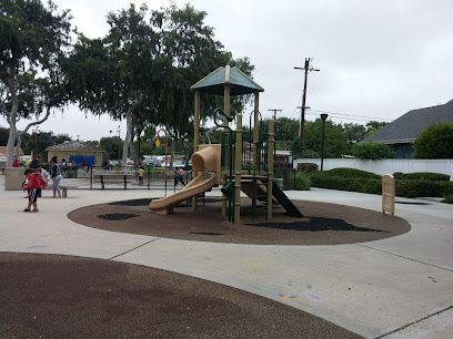Playground with slide, climbing structure, and children playing on a cloudy day.