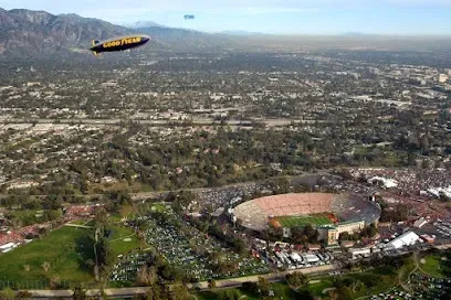An aerial view of a stadium with a zeppelin flying over it.