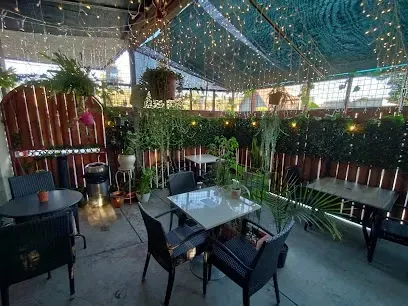 A patio with tables and chairs under a canopy.