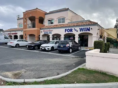 A row of cars are parked in front of a building that says `` for win ''.