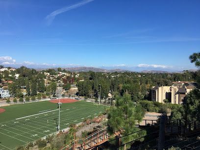 Football field and surrounding neighborhood on a sunny day.