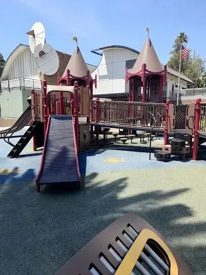 tree service close to me-Playground with brown and tan structures, slides, and bridges; a blue-and-green padded ground.