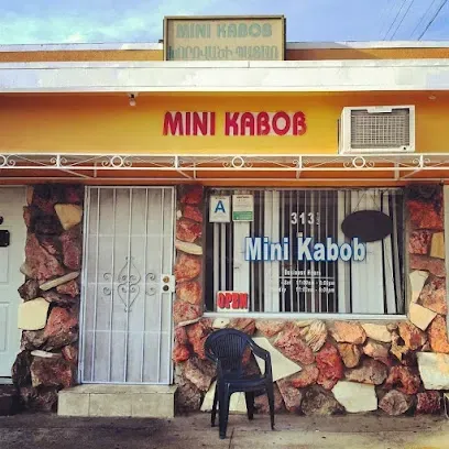 A yellow building with a sign that says mini kabob