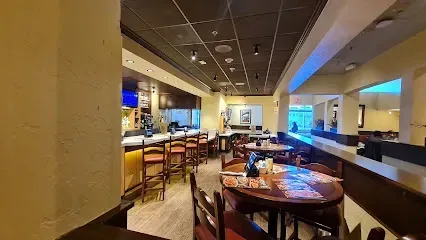 A restaurant with tables and chairs and a bar.