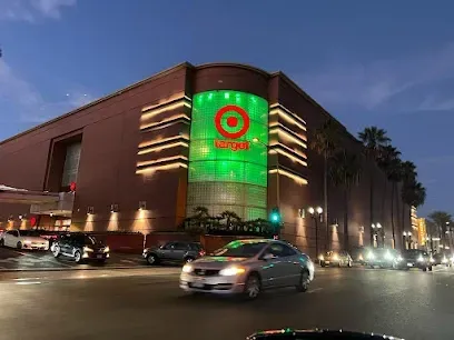 A car is driving past a target store at night.