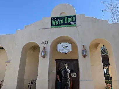 Two men are standing in front of a building with a sign that says `` we 're open ''.