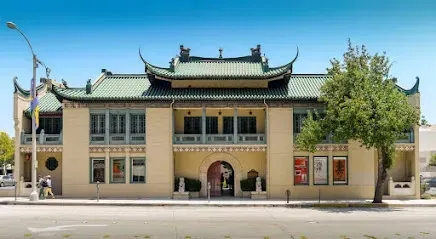 A large building with a green roof and a tree in front of it.