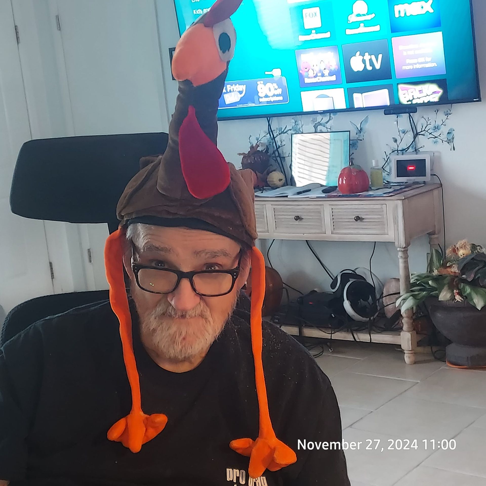 Man wearing a turkey hat with long orange legs.