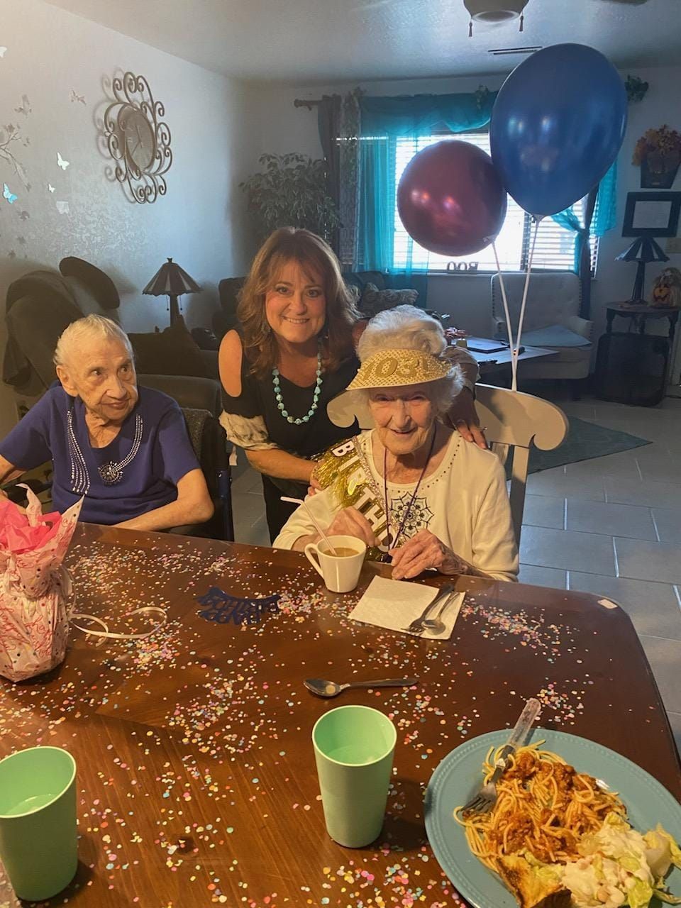 Three women at a table celebrating.