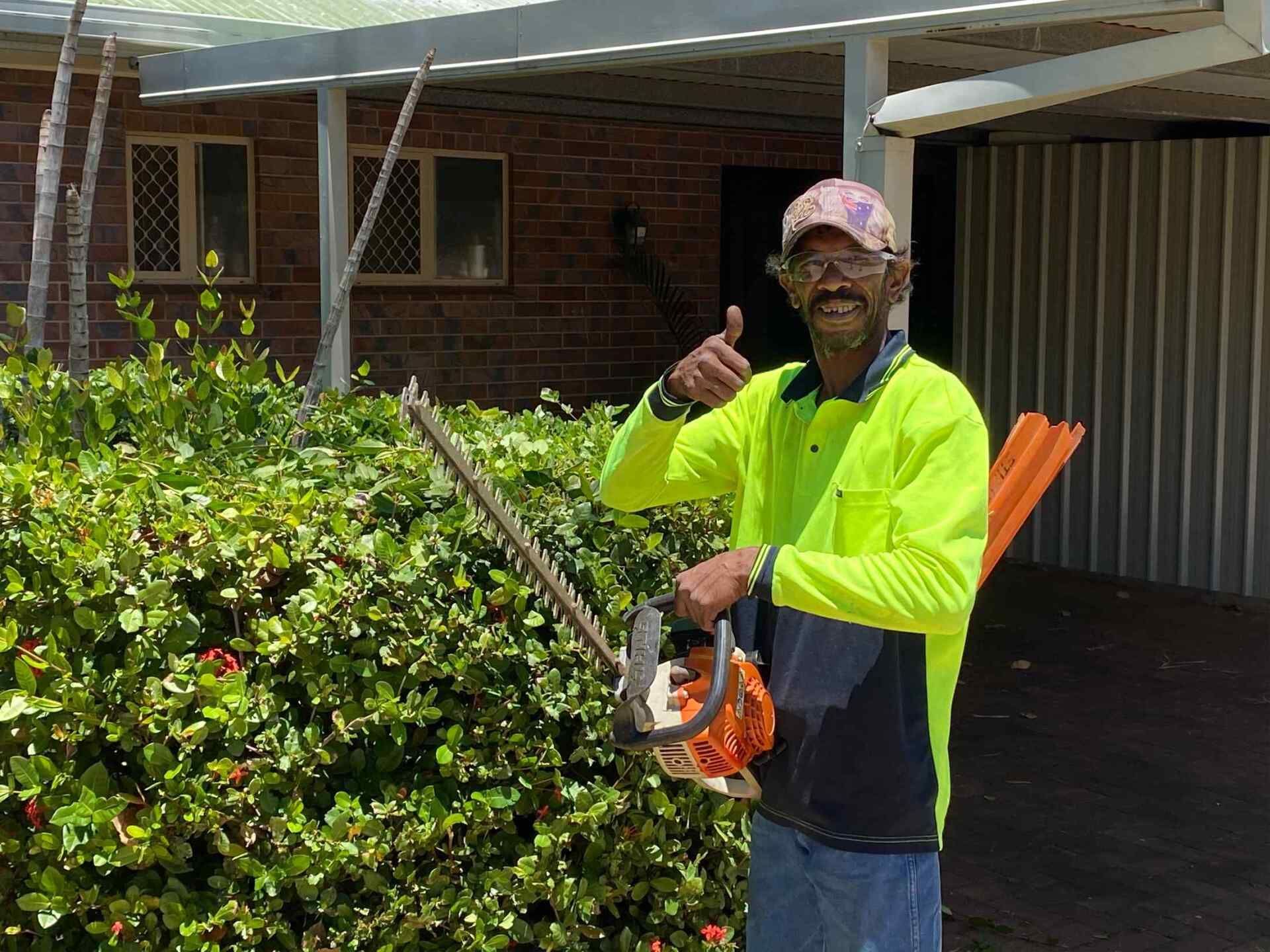 Man in Neon Shirt Holds Hedge Trimmer, Thumbs Up — Darrell's Mowing Services in Sunset, QLD