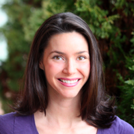 A woman in a purple shirt is smiling for the camera