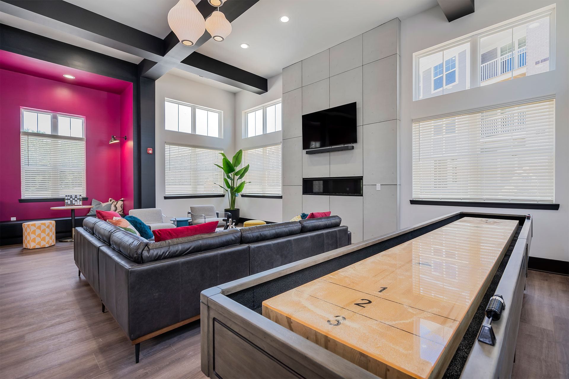 A room with a shiny wooden table and a couch.