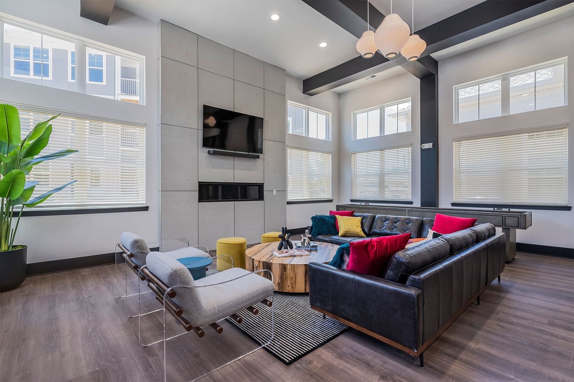 A modern resident lounge with a black couch and a grey chair.