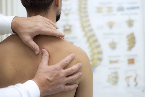 A man is getting a massage from a doctor.