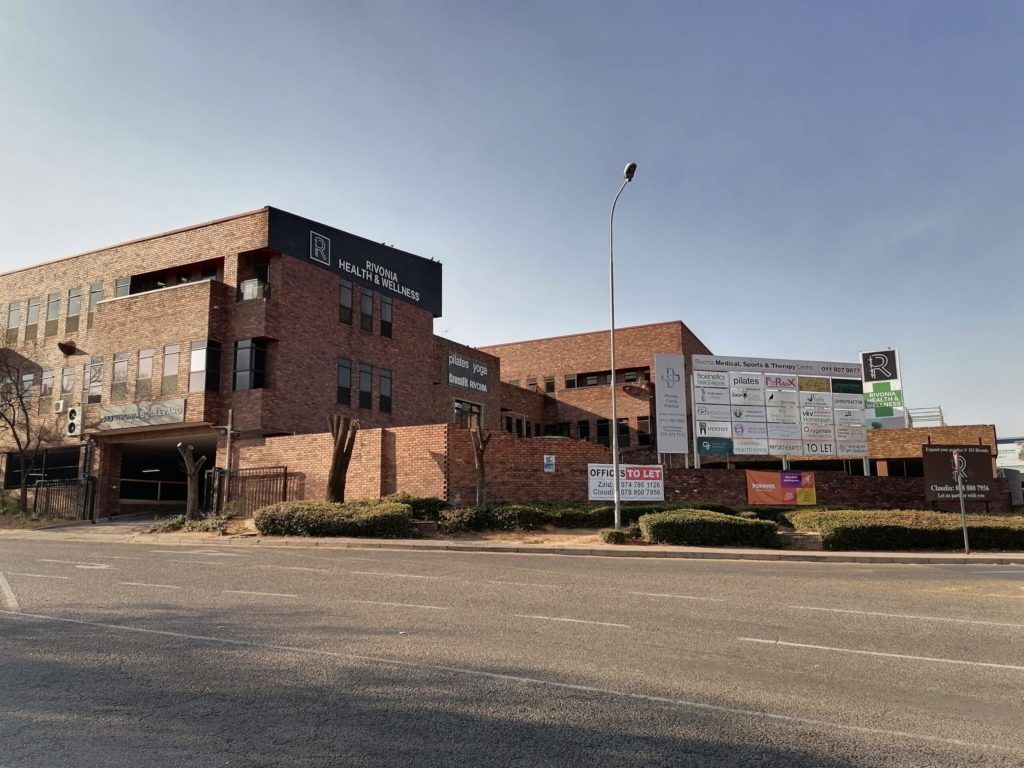 A large brick building is sitting on the corner of a street.
