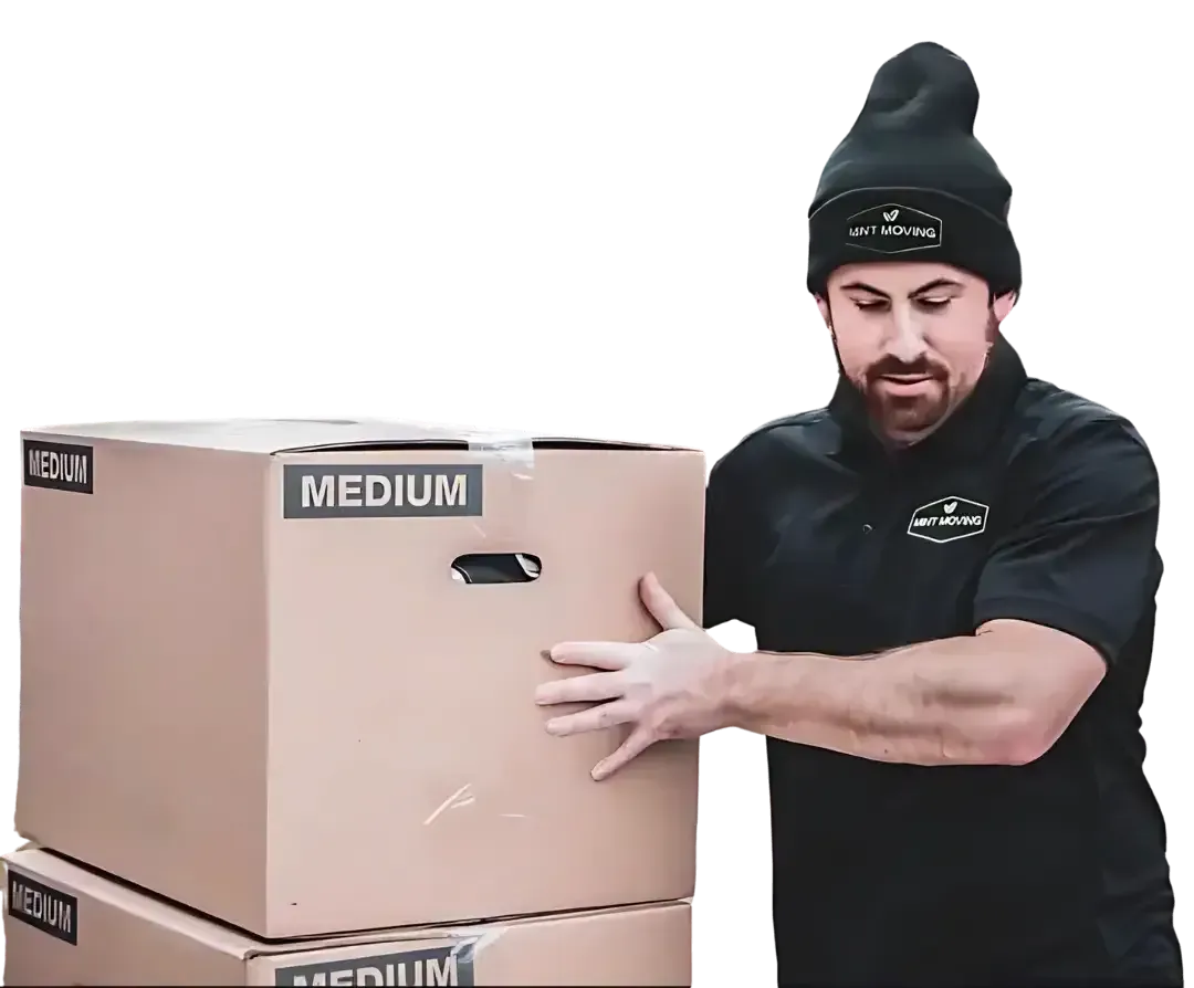 Man in black shirt and beanie, holding a medium-sized cardboard box.