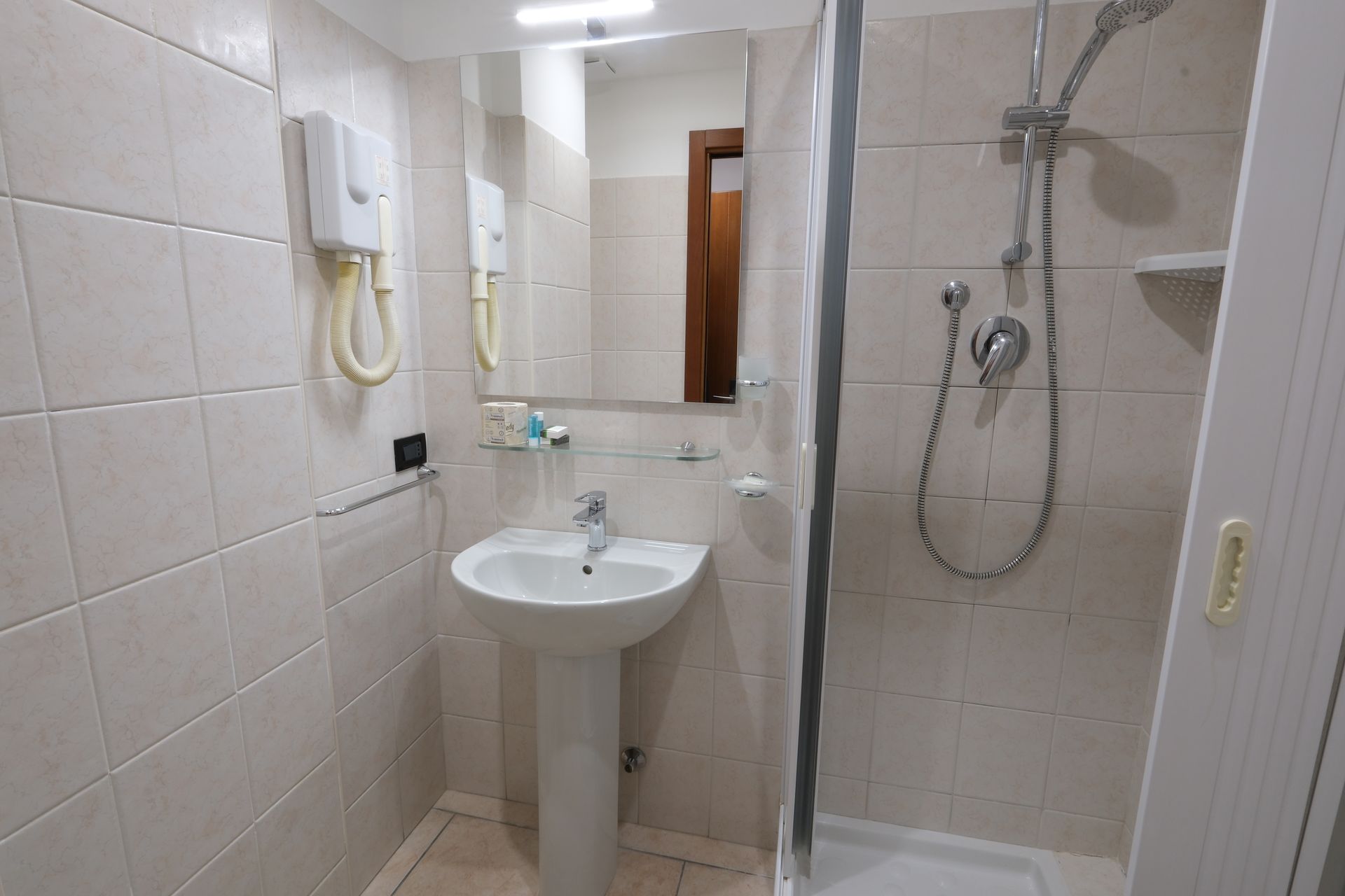 Ванная комната с раковиной, душем и зеркалом.