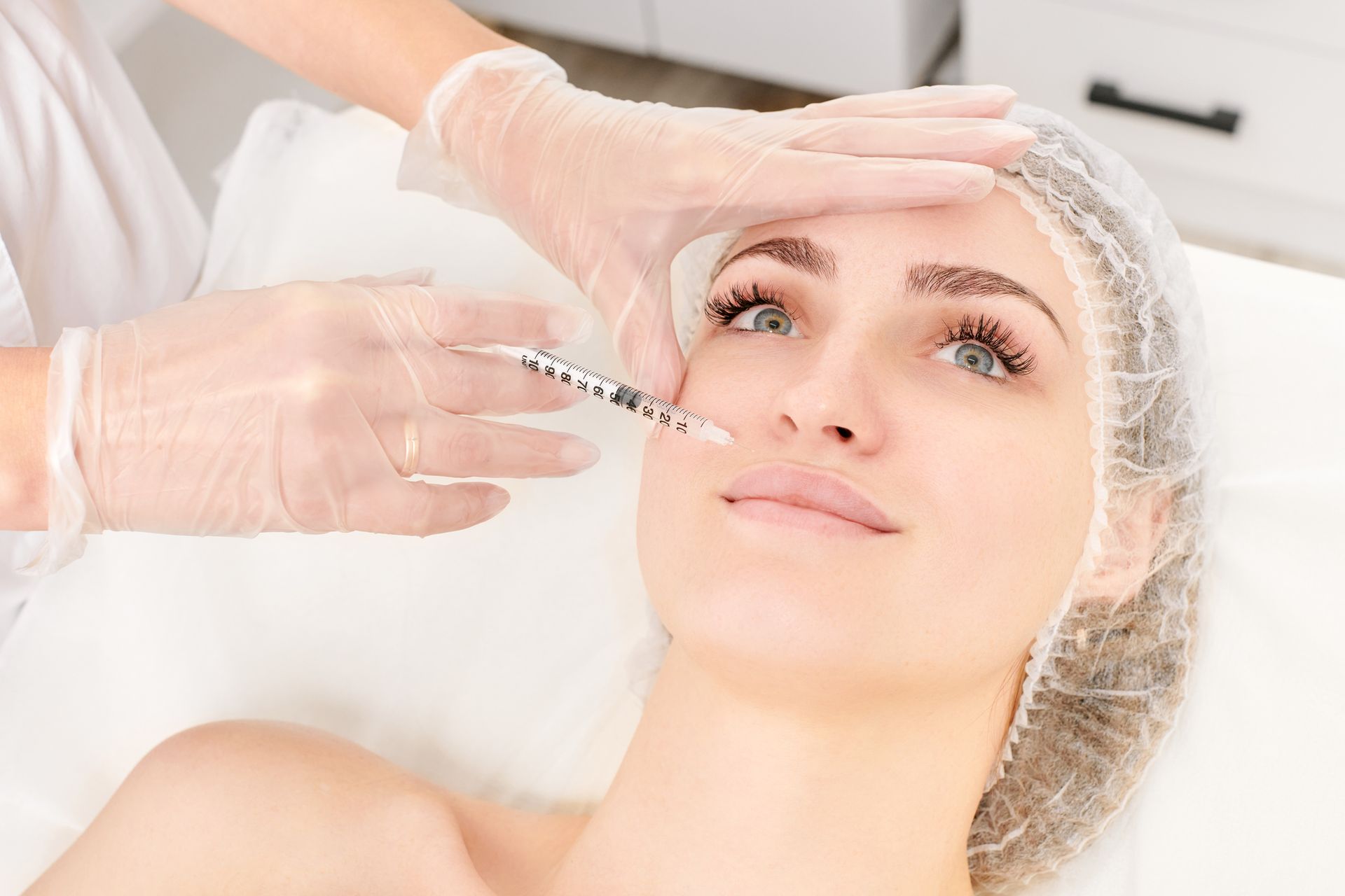 A Woman is Getting a Serum Injection in her Face — Tustin, CA — Dr. Assif Med Spa