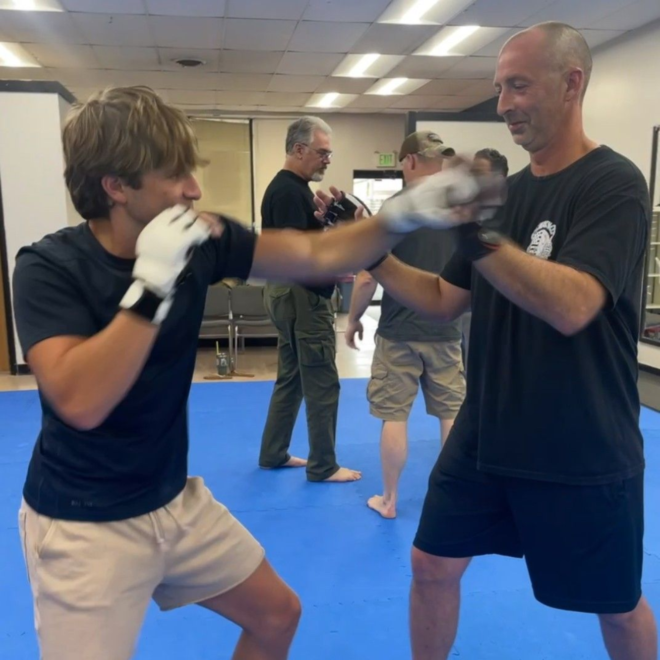 Two young men are practicing karate on a mat