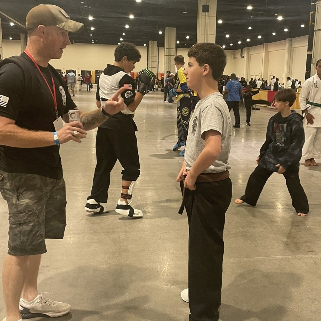 A group of men are practicing karate in a gym.