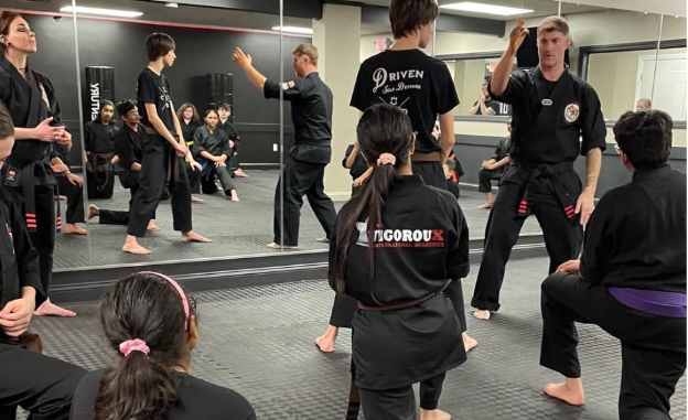 A person is holding a sparkler in their hand in the dark.