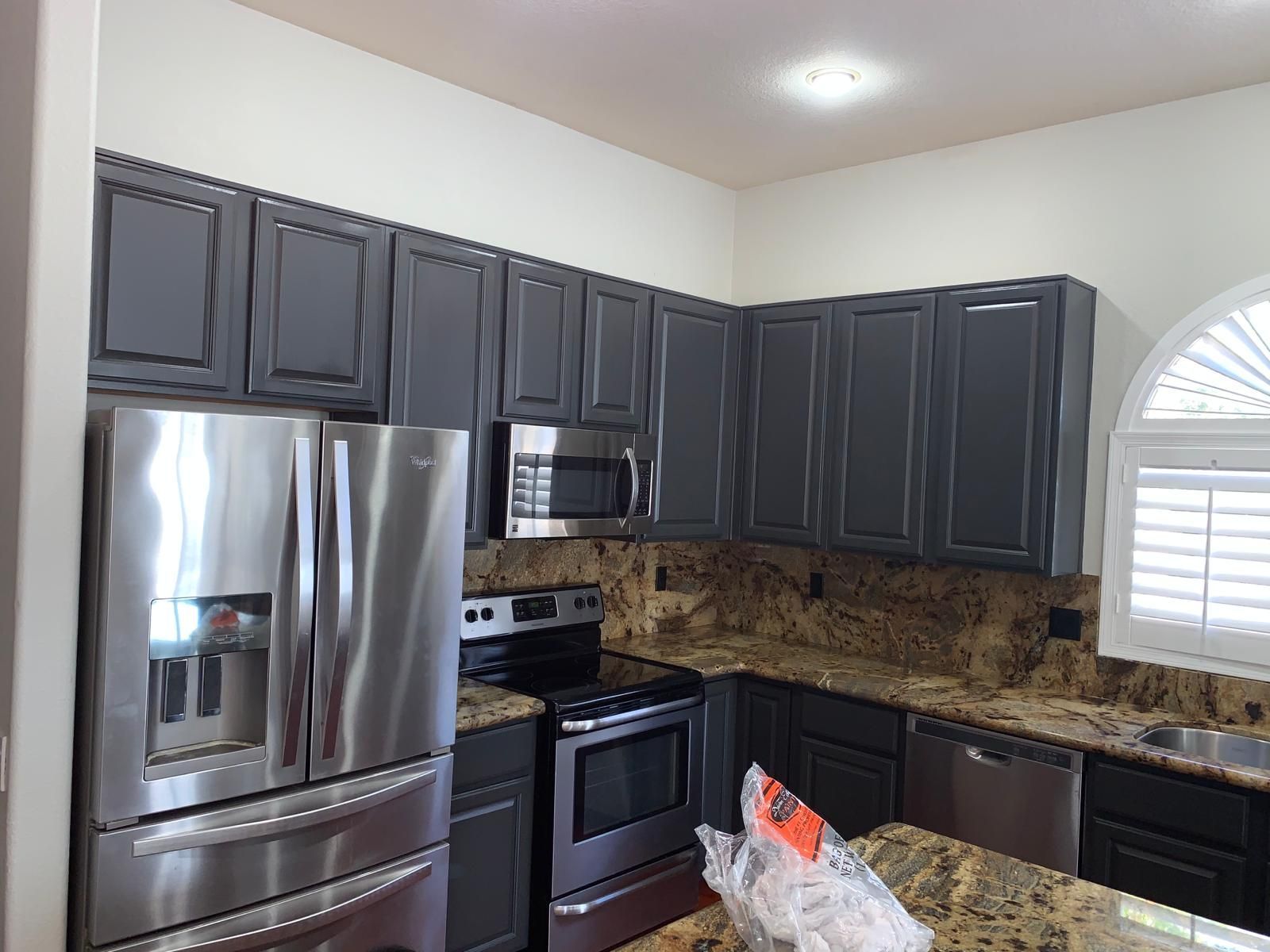 Kitchen with gray cabinets, stainless steel appliances, and granite countertops.