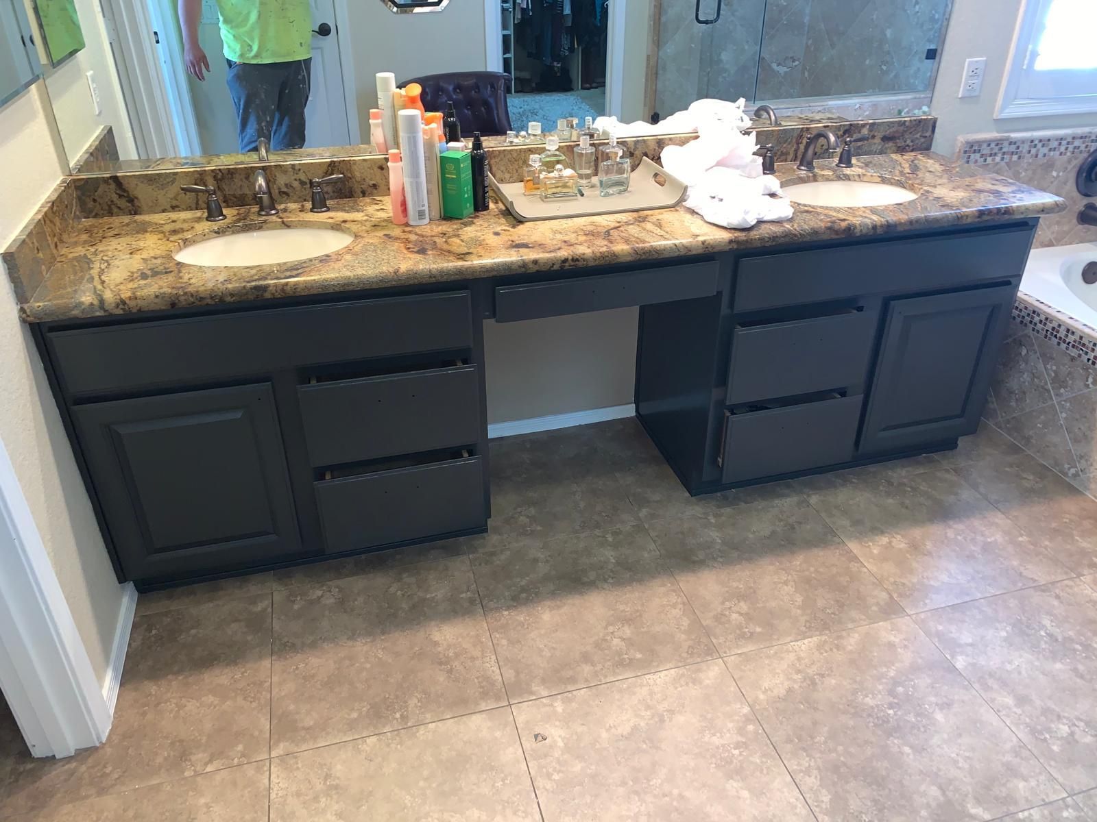 Bathroom vanity with two sinks, dark gray cabinets, and granite countertop.