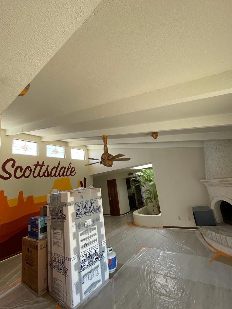 Interior of a room with exposed beams and a Scottsdale mural. Packing supplies in the foreground.