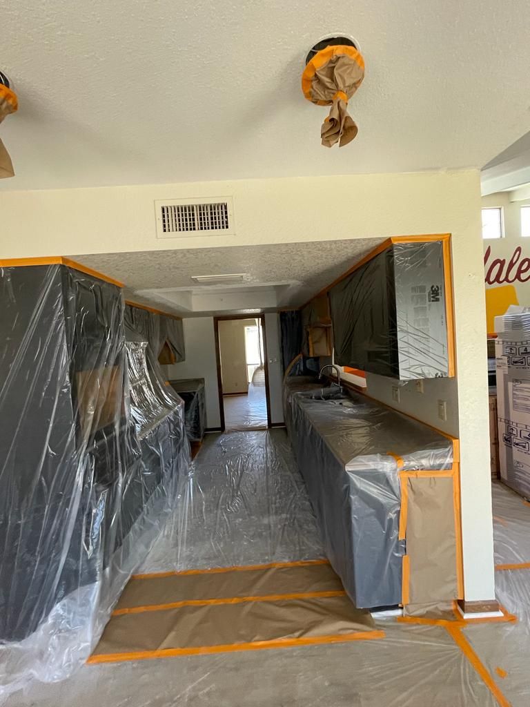 Kitchen renovation with covered cabinets and countertops. Walls and floor covered for protection.