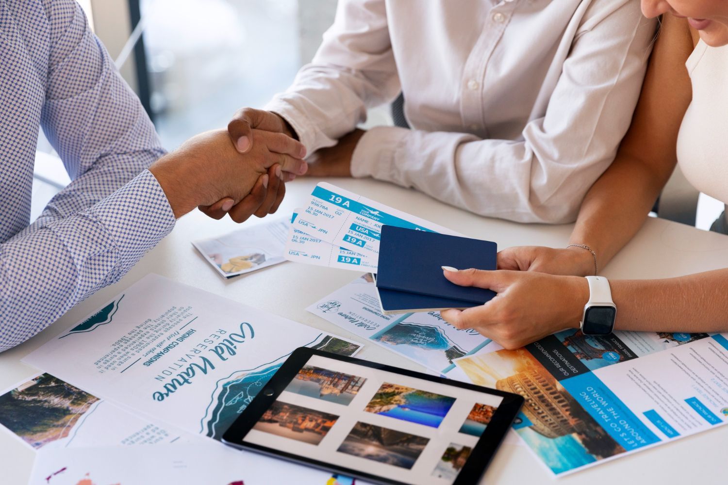 A man and a woman are shaking hands over a table.