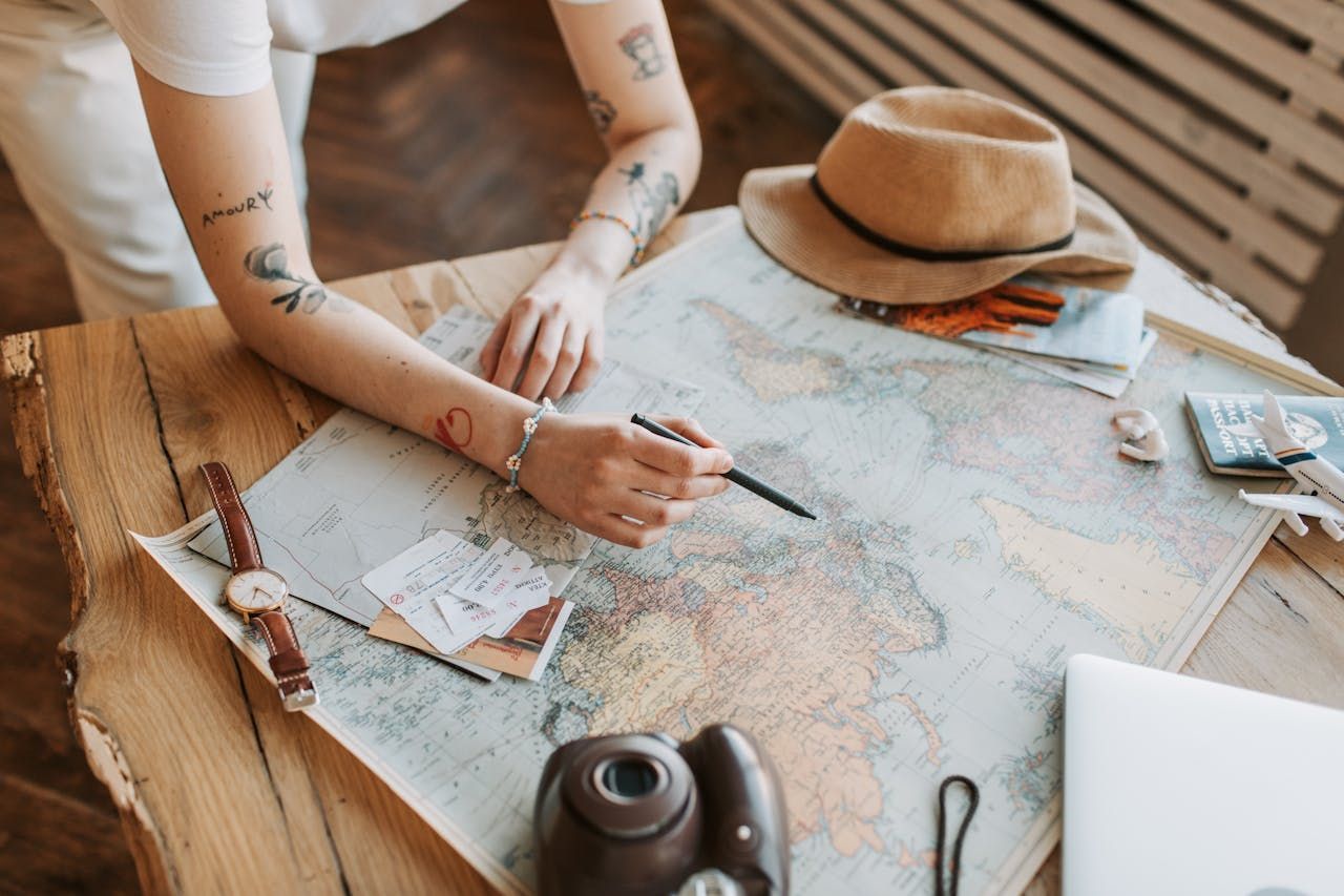 A woman is sitting at a table looking at a map.