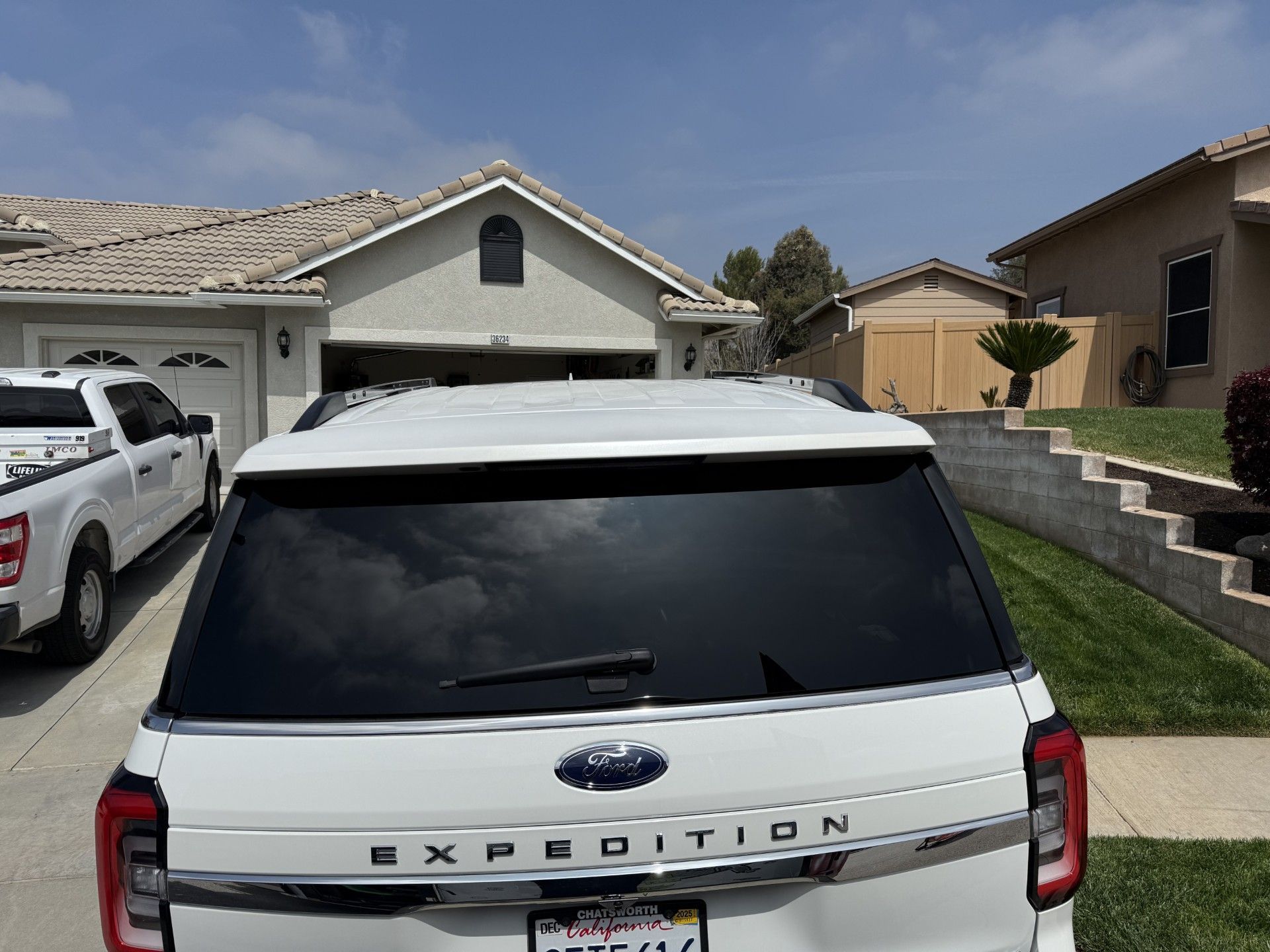 A white ford expedition is parked in front of a house