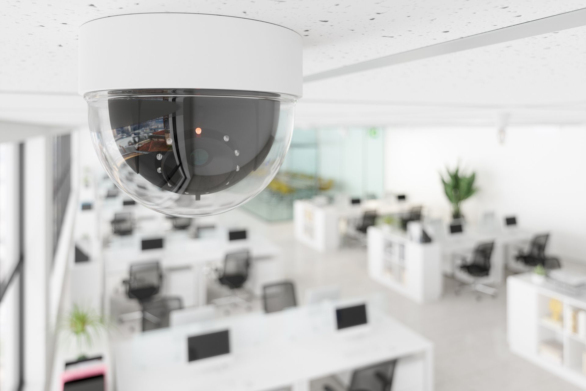 Close-up of a business CCTV camera in an open plan blurry office.