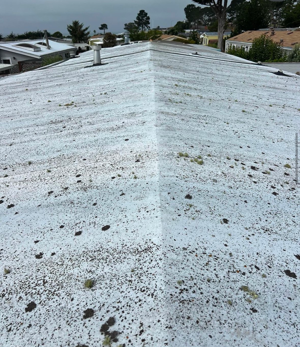 A white roof with a lot of dirt on it.