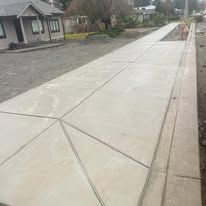 Newly constructed concrete sidewalk in front of a house.