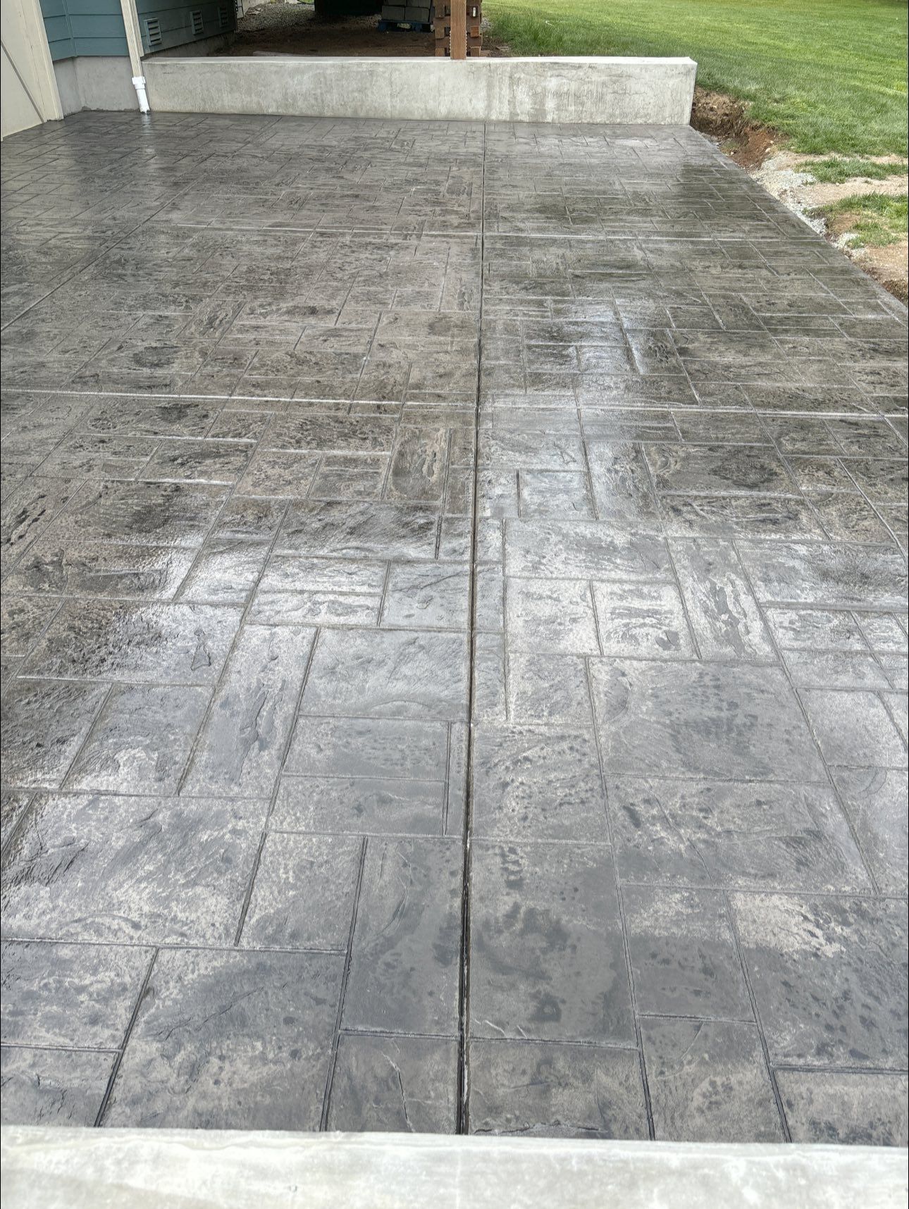 Gray stamped concrete patio with geometric design.