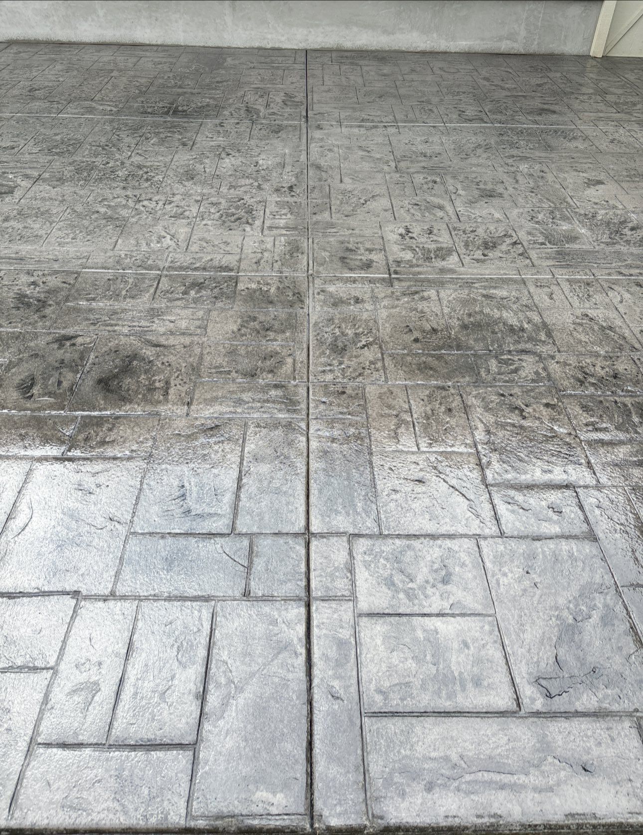 Gray stamped concrete patio with grid pattern.
