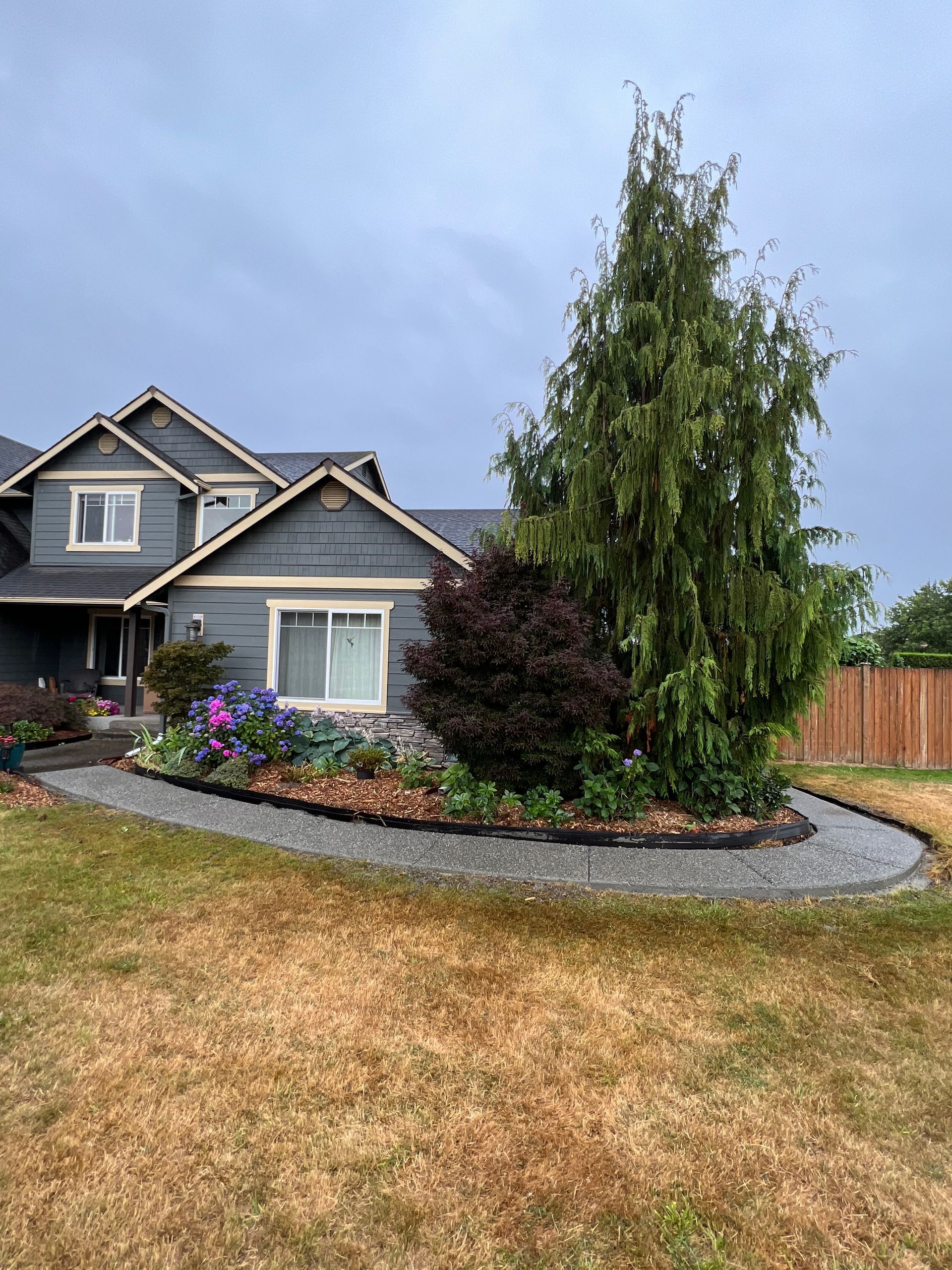 Concrete patio with dark border and decorative stone.