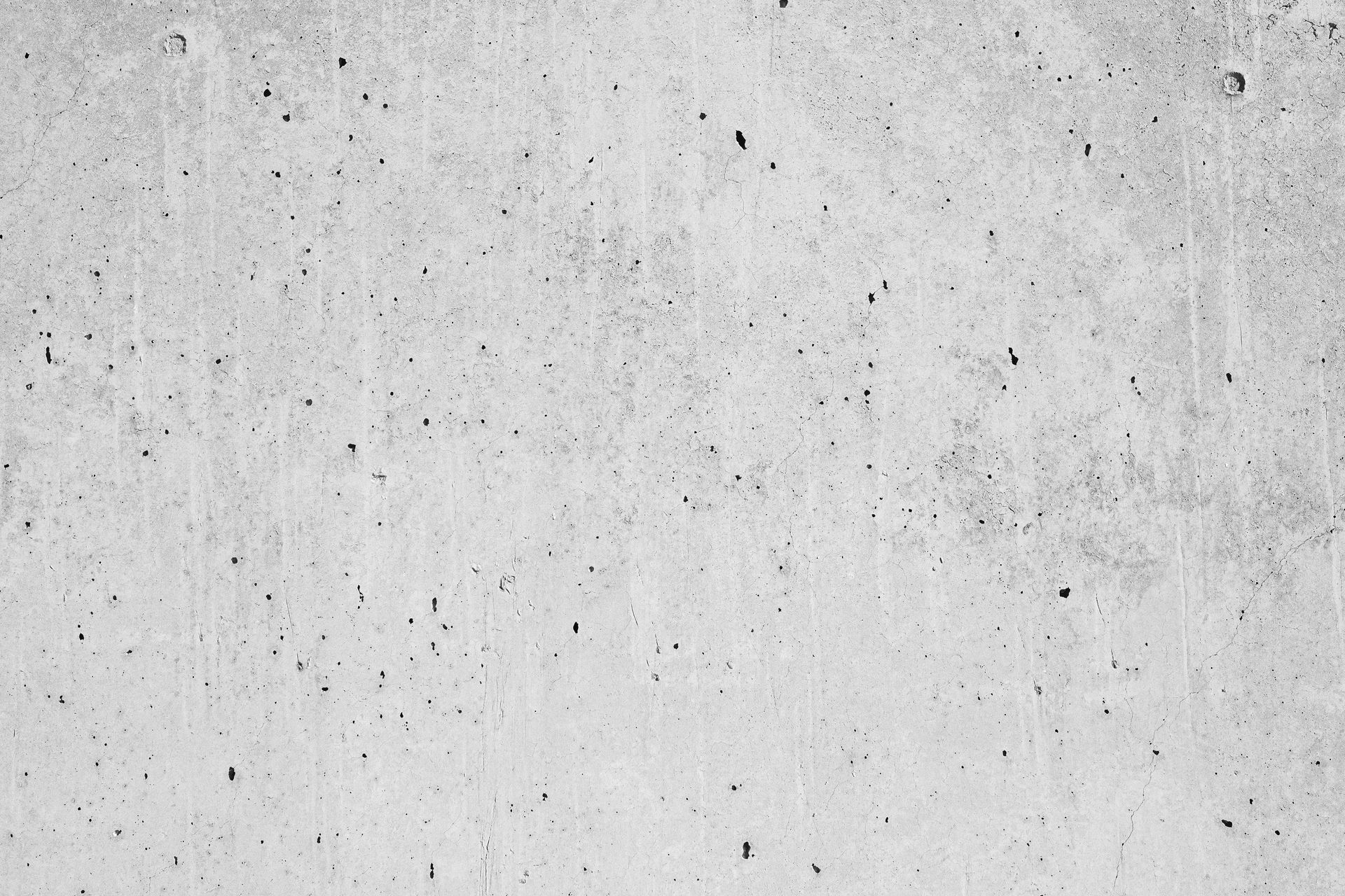 Gray concrete wall with a rough, textured surface and small dark specks.
