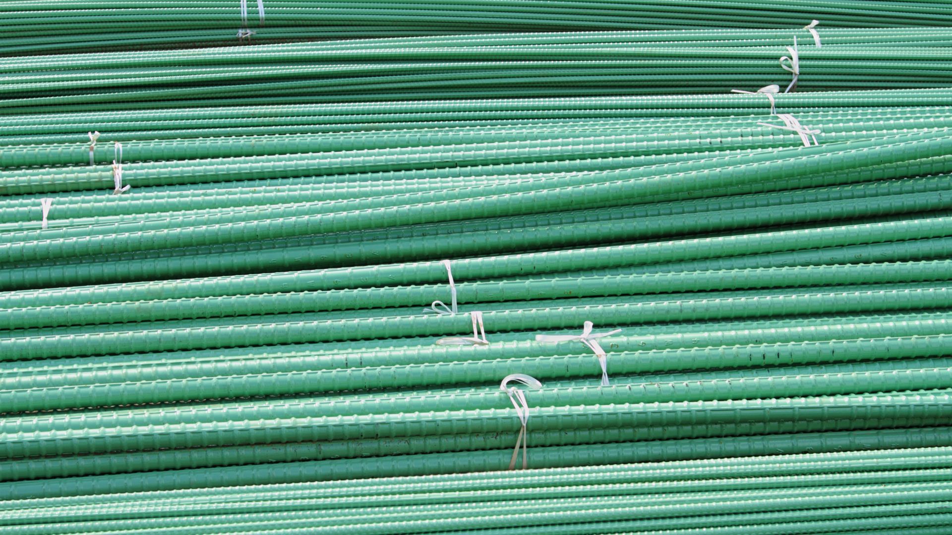 A bunch of green pipes are stacked on top of each other