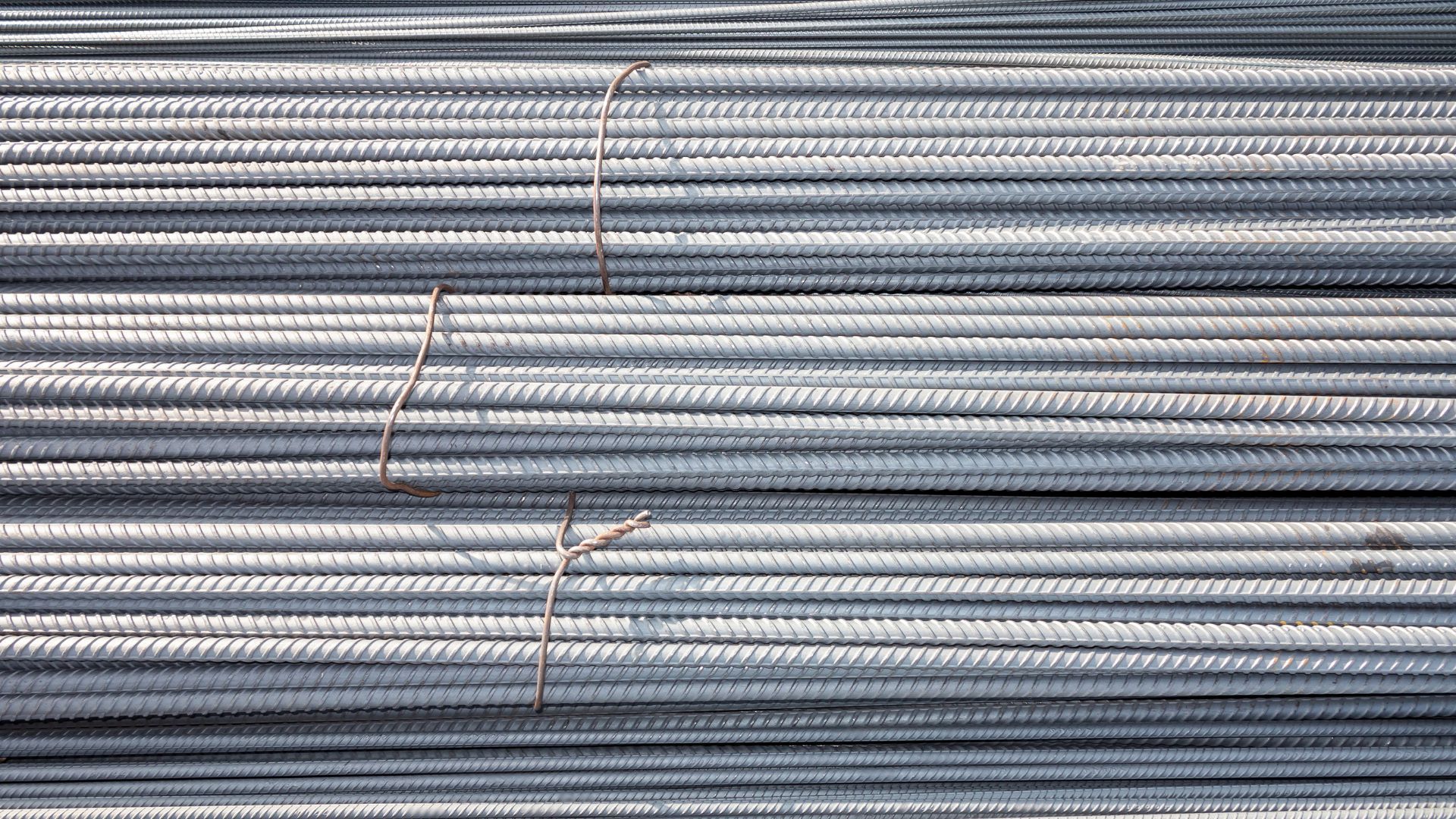 A person wearing yellow gloves is working on a construction site.