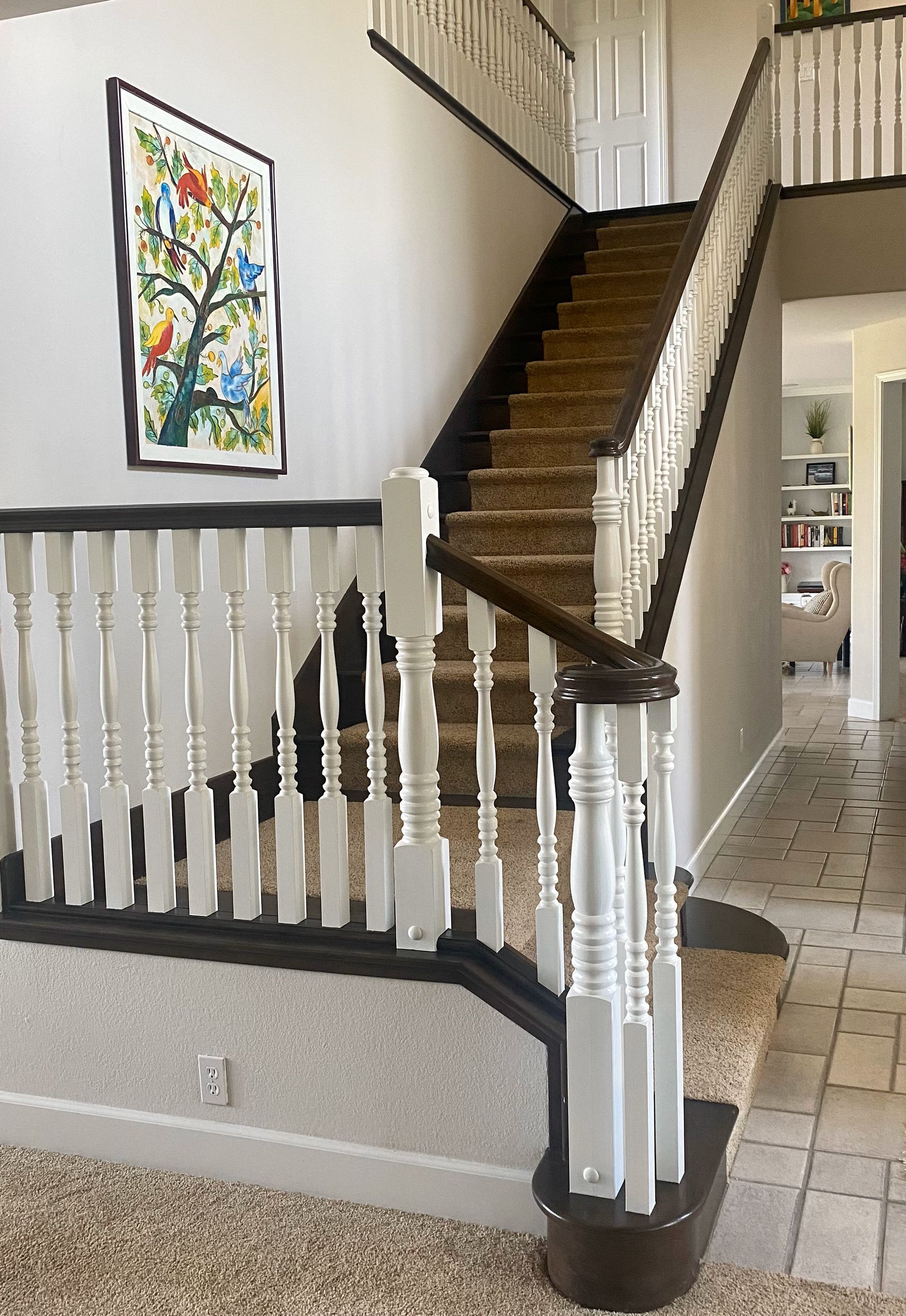 A staircase in a house with a picture on the wall above it